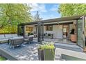 Relax in style on the backyard deck with seating, which transitions seamlessly into a glass-enclosed sunroom at 5525 E Bails Dr, Denver, CO 80222
