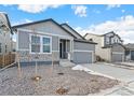 Two-story house with gray siding, stone accents, and a two-car garage at 13412 E 110Th Way, Commerce City, CO 80022