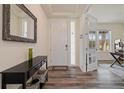 Inviting entryway with wood floors, a stylish console table, and a view into a bright office at 16341 Clayton St, Thornton, CO 80602