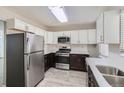Modern kitchen with stainless steel appliances, white upper cabinets, and dark lower cabinets, showcasing style and functionality at 384 S Decatur St, Denver, CO 80219