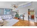 Bright living room featuring hardwood floors, a large sectional sofa, and clerestory windows at 6018 Owens St, Arvada, CO 80004