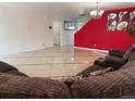 View of the living room, with tile flooring and a red accent wall, with a plush couch in the foreground at 21561 E 48Th Pl, Denver, CO 80249