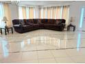 Spacious living room with tile flooring, large sectional sofa, and elegant chandelier at 21561 E 48Th Pl, Denver, CO 80249