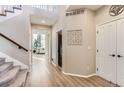 Open hallway with staircase, light wood floors, and natural light filtering through nearby rooms at 11013 Valleybrook Cir, Highlands Ranch, CO 80130