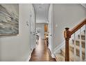 Inviting hallway with beautiful hardwood floors and stairway to the upper level at 3129 Open Sky Way, Castle Rock, CO 80109