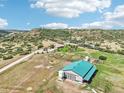 Expansive property featuring a home and large outbuilding, set against a scenic hillside at 5285 E State Highway 86, Franktown, CO 80116