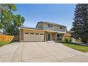 Beautiful house with a spacious driveway, green lawn, mature trees, and solar panels on the roof at 6121 W 108Th Ave, Westminster, CO 80020