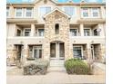 Multi-story townhouse featuring stone accents, multiple balconies, and tandem entry doors at 1509 S Florence Ct # 218, Aurora, CO 80247