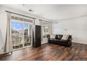 Bright living room with hardwood floors, plenty of light from the large windows, and a leather couch at 1509 S Florence Ct # 218, Aurora, CO 80247