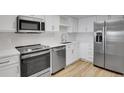 Modern kitchen boasts stainless steel appliances, white cabinets, and sleek countertops at 14001 E Marina Dr # 603, Aurora, CO 80014