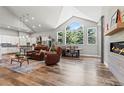 Bright living room with vaulted ceilings, large windows, and hardwood floors open to kitchen at 6532 S Tempe St, Aurora, CO 80016