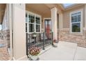 Charming covered front porch with seating and decorative potted flowers, perfect for relaxing at 25049 E Alder Dr, Aurora, CO 80016
