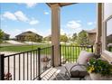 Inviting covered front porch area with comfortable seating, decorative flowers, and an iron railing at 25049 E Alder Dr, Aurora, CO 80016