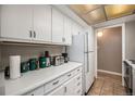 Bright kitchen featuring white cabinets, modern appliances, and tile flooring at 10115 W 25Th Ave # 1, Lakewood, CO 80215