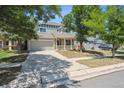 This lovely home showcases a well-manicured lawn, a two-car garage, and beautiful trees in the front yard at 5229 Nighthawk Pkwy, Brighton, CO 80601
