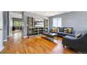 Cozy living room features hardwood floors, a decorative shelving unit and gray modern sofa at 5229 Nighthawk Pkwy, Brighton, CO 80601