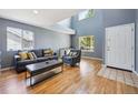 Bright living room with large windows, hardwood floors, and stylish gray furnishings at 5229 Nighthawk Pkwy, Brighton, CO 80601