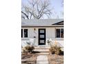 Close-up view of the front porch with a modern black front door and brickwork facade at 965 S Jersey St, Denver, CO 80224