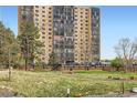 Exterior view of condo building featuring well-maintained lawn and trees at 7865 E Mississippi Ave # 304, Denver, CO 80247