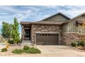 Home exterior featuring a stone facade, two car garage, and well manicured landscaping at 3367 New Haven Cir, Castle Rock, CO 80109