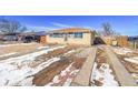 Cozy one-story home boasts a brick and wood exterior, large driveway, and well-kept yard at 1281 Myrtle St, Brighton, CO 80601