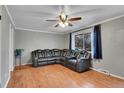 The cozy living room includes wood floors, a ceiling fan, and a large reclining sectional at 1281 Myrtle St, Brighton, CO 80601