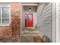 Close-up of the front porch, showcasing a red door, brickwork, and decorative elements at 7975 S Gaylord Way, Centennial, CO 80122