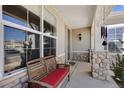 Cozy front porch features stone columns and a comfortable bench, perfect for relaxing at 4932 Democrat Dr, Broomfield, CO 80023