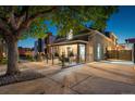 Charming exterior with covered porch, rod iron fencing, mature tree and welcoming lighting at 1832 W 33Rd Ave, Denver, CO 80211