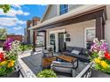 Inviting front porch with ample seating, swing, stylish decor and flowers at 1832 W 33Rd Ave, Denver, CO 80211