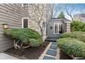 Landscaped front entrance featuring stone pavers, pea gravel and mature shrubbery at 1585 W Briarwood Ave, Littleton, CO 80120