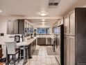 This kitchen features stainless appliances, tile floors, and custom cabinets with a modern aesthetic at 40 Benton St, Lakewood, CO 80226