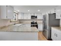 Eat-in kitchen features stainless steel appliances, bright white cabinets, and granite countertops at 5603 S Pagosa Ct, Centennial, CO 80015