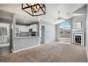Inviting living room featuring modern lighting, fireplace, and seamless flow into a kitchen with stainless steel appliances at 8777 E Dry Creek Rd # 1426, Englewood, CO 80112