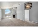 Bright and spacious living room featuring vaulted ceiling, fireplace, and large arched window at 8777 E Dry Creek Rd # 1426, Englewood, CO 80112