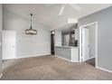 Open concept living room showcasing modern lighting and bar, seamlessly connecting to a kitchen at 8777 E Dry Creek Rd # 1426, Englewood, CO 80112