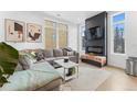 Comfortable living room with a large gray couch, decorative fireplace, and abundant natural light at 1232 N Yates St # 3, Denver, CO 80204