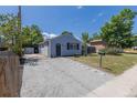 Charming light-blue home with large driveway, tidy front yard, and black shutters at 3570 Center Ave, Denver, CO 80219