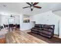 Open-concept living room with a leather sofa, and hardwood floors at 10129 Glencoe Ct, Thornton, CO 80229