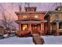 Charming brick home with covered front porch, steps and seasonal landscaping at 1586 Steele St, Denver, CO 80206