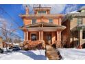 Brick home with covered front porch, steps and seasonal landscaping on a sunny winter day at 1586 Steele St, Denver, CO 80206