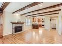 Inviting living room featuring hardwood floors, a brick fireplace, and a seamless flow into the updated kitchen at 6731 S Kearney Ct, Centennial, CO 80112