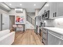 Open-concept living space features stainless steel appliances, modern staircase, and contemporary decor at 3219 W 19Th Ave # 3, Denver, CO 80204