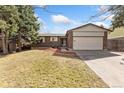 Charming single-story home featuring a brick facade, a two-car garage, and a spacious driveway at 15104 E Utah Pl, Aurora, CO 80012