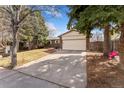 Charming single-story home featuring a brick facade, a two-car garage, and a spacious driveway at 15104 E Utah Pl, Aurora, CO 80012