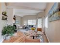 Bright open concept living and dining area with white beams, wood floors, and a fireplace at 9288 Krashin Dr, Conifer, CO 80433