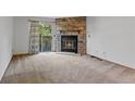 Living room boasts a stone fireplace with glass doors and a sliding door to a deck at 12043 E Ford Cir, Aurora, CO 80012