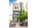 Charming three-story townhome features a stone column, a small patio and landscaped front yard at 15878 E Broncos Pl, Englewood, CO 80112