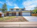 Charming two-story home featuring a brick facade, two-car garage, and a well-maintained front yard at 8694 E Eastman Ave, Denver, CO 80231