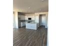 Bright kitchen featuring an island, stainless appliances, white cabinets, and hardwood floors at 7360 Watercress Dr, Littleton, CO 80125